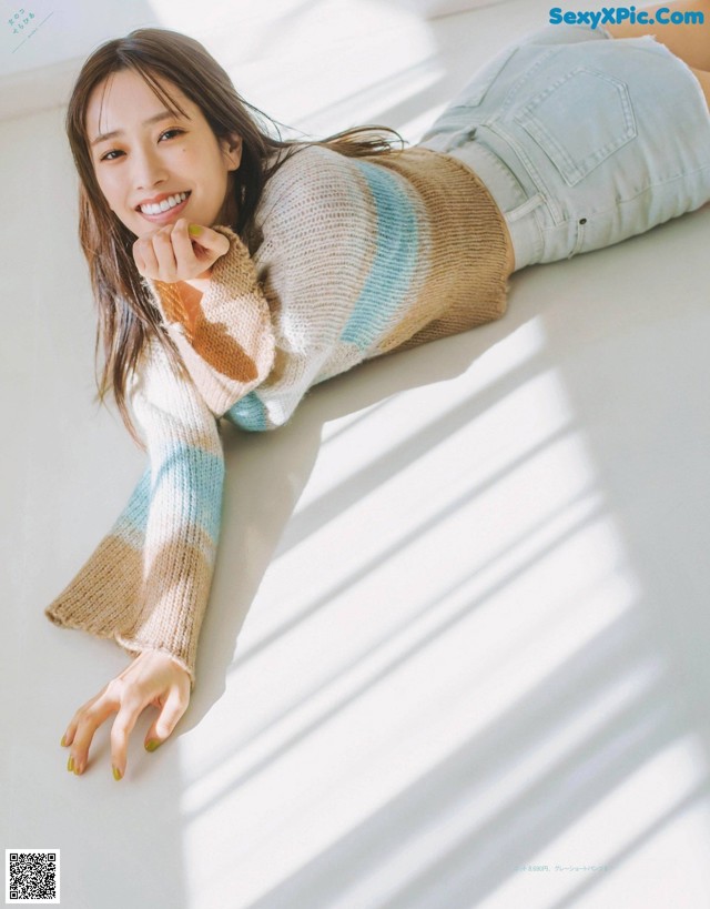 A woman laying on the floor with her hand on her chin.