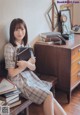 A woman sitting on a bench holding a book.