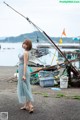 A woman standing in front of a body of water.